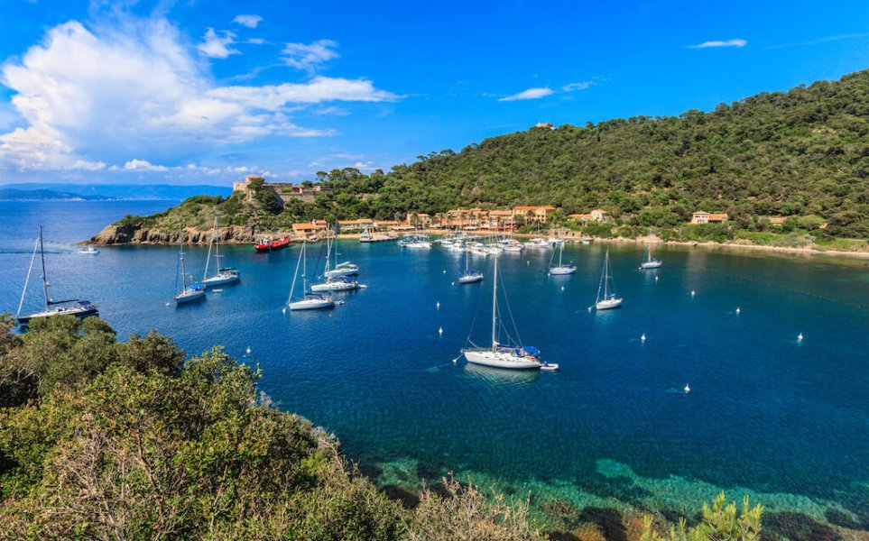 Plage avec des bateaux au large.